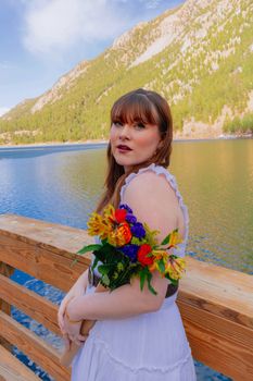 Spring portrait of a woman holding flowers by a scenic mountain lake in Georgetown, Colorado.