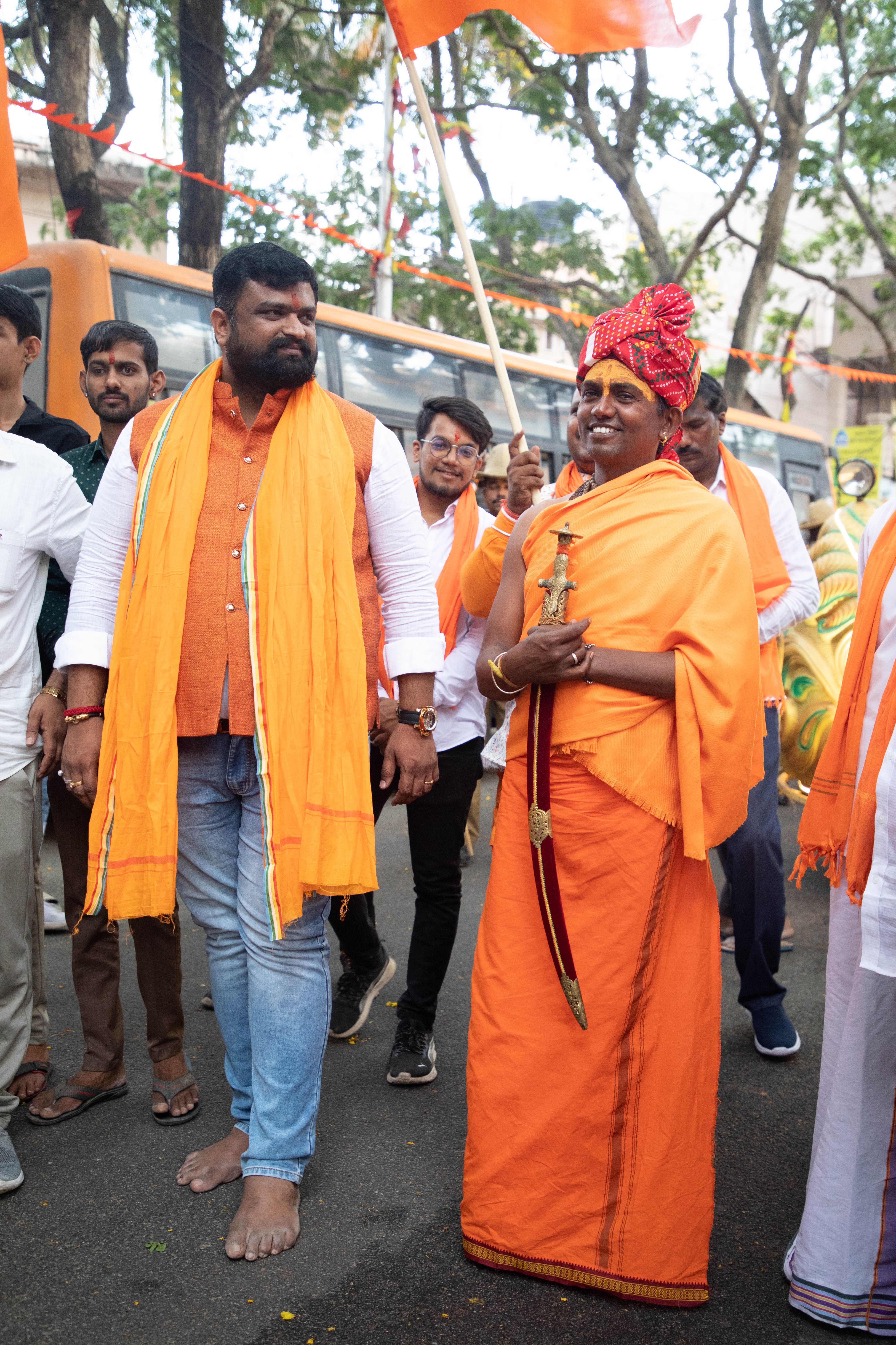 A vibrant cultural parade featuring individuals in traditional attire holding flags and swords.