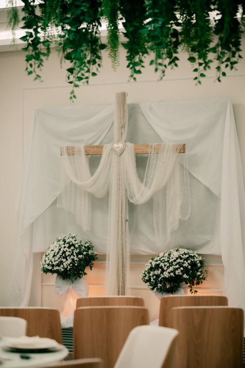 Free Beautifully decorated indoor wedding venue with floral and cross arrangements. Stock Photo