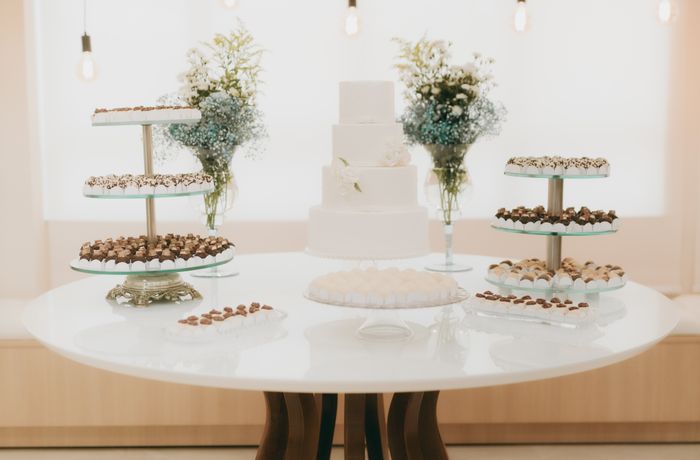 Dessert table styled with greenery, cakes and pastries