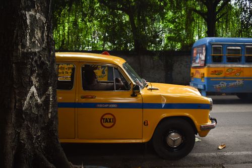 Free Classic yellow taxi navigating the bustling streets of Kolkata with vintage charm. Stock Photo