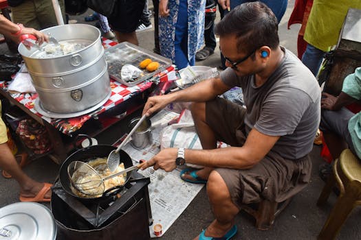 A street vendor prepares dumplings in a bustling Kolkata market, offering a glimpse into Indian street food culture.