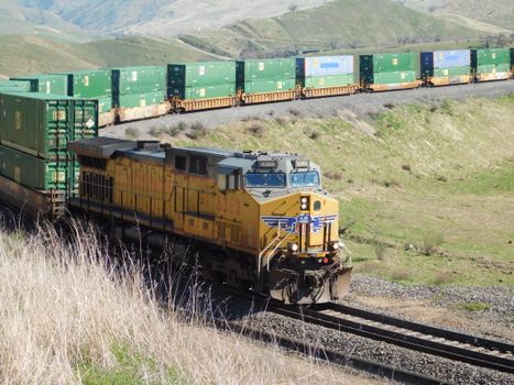 A Union Pacific freight train travels through the scenic hills of California, USA.