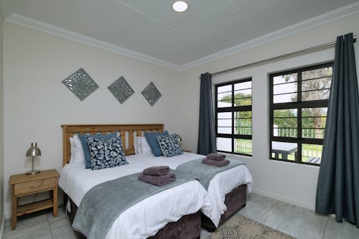 Modern bedroom with natural light, twin beds, and elegant decor.