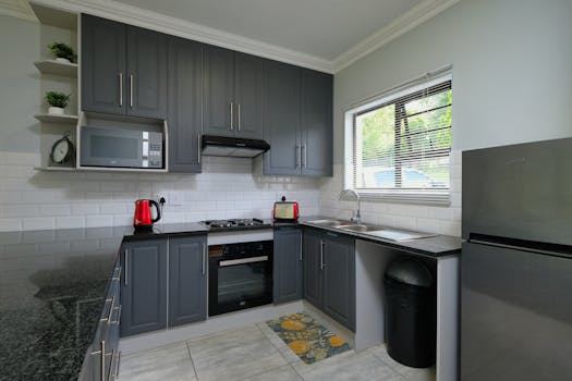 Sleek modern kitchen featuring dark cabinets and stainless steel appliances.
