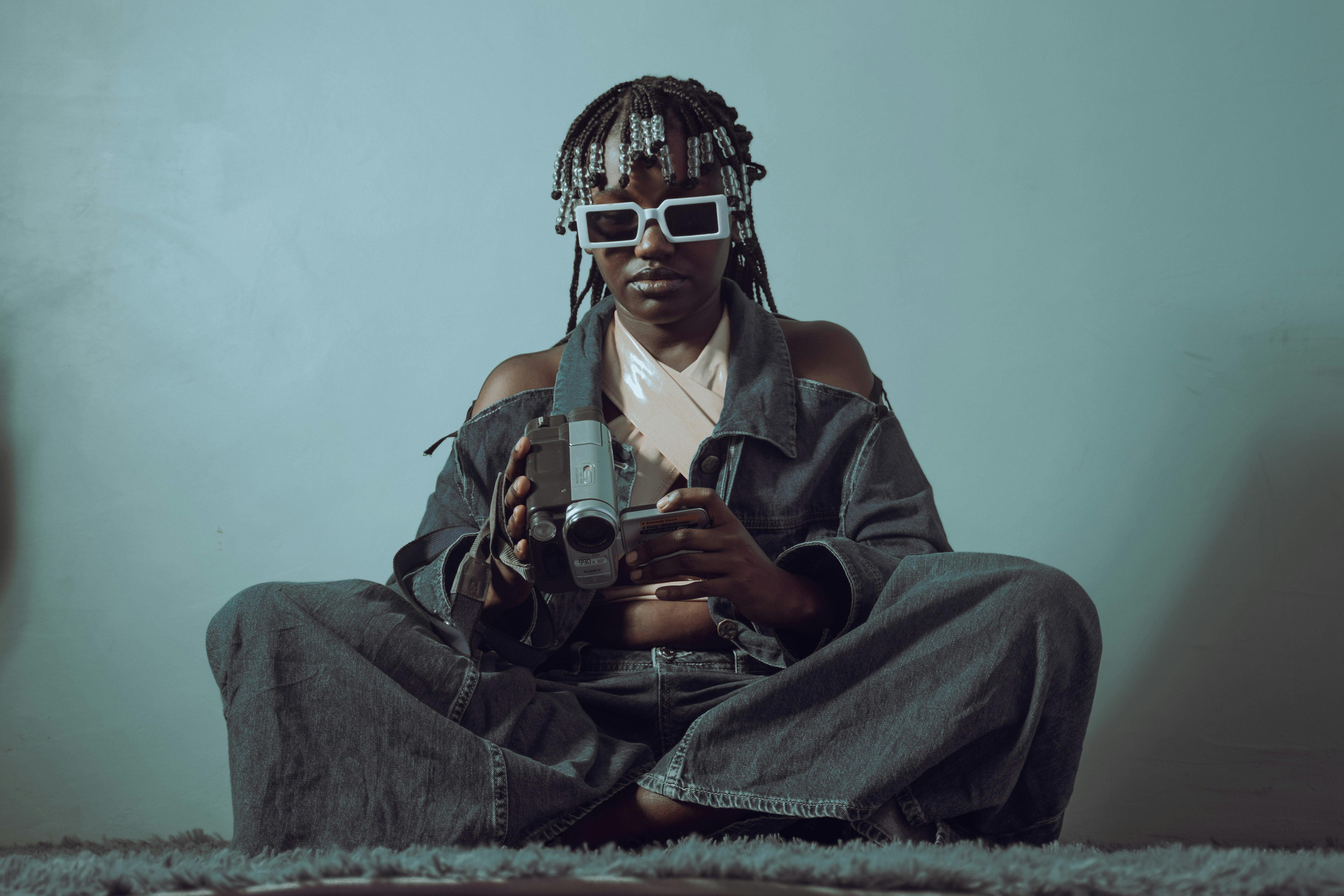 A trendy individual in denim holding a vintage camera, exuding a cool vibe.