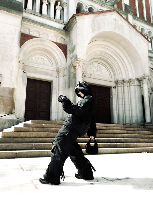 Free Person in gothic attire posing dramatically outside an old cathedral. Stock Photo