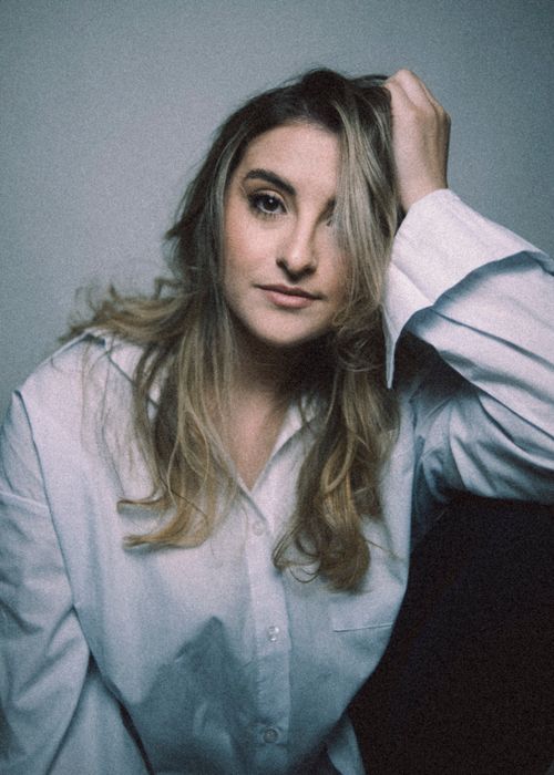 Free Moody portrait of a woman with long hair wearing a white shirt, indoors. Stock Photo