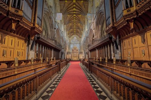 Free Beautiful interior of Selby Abbey featuring Gothic architecture and vibrant red carpet. Stock Photo