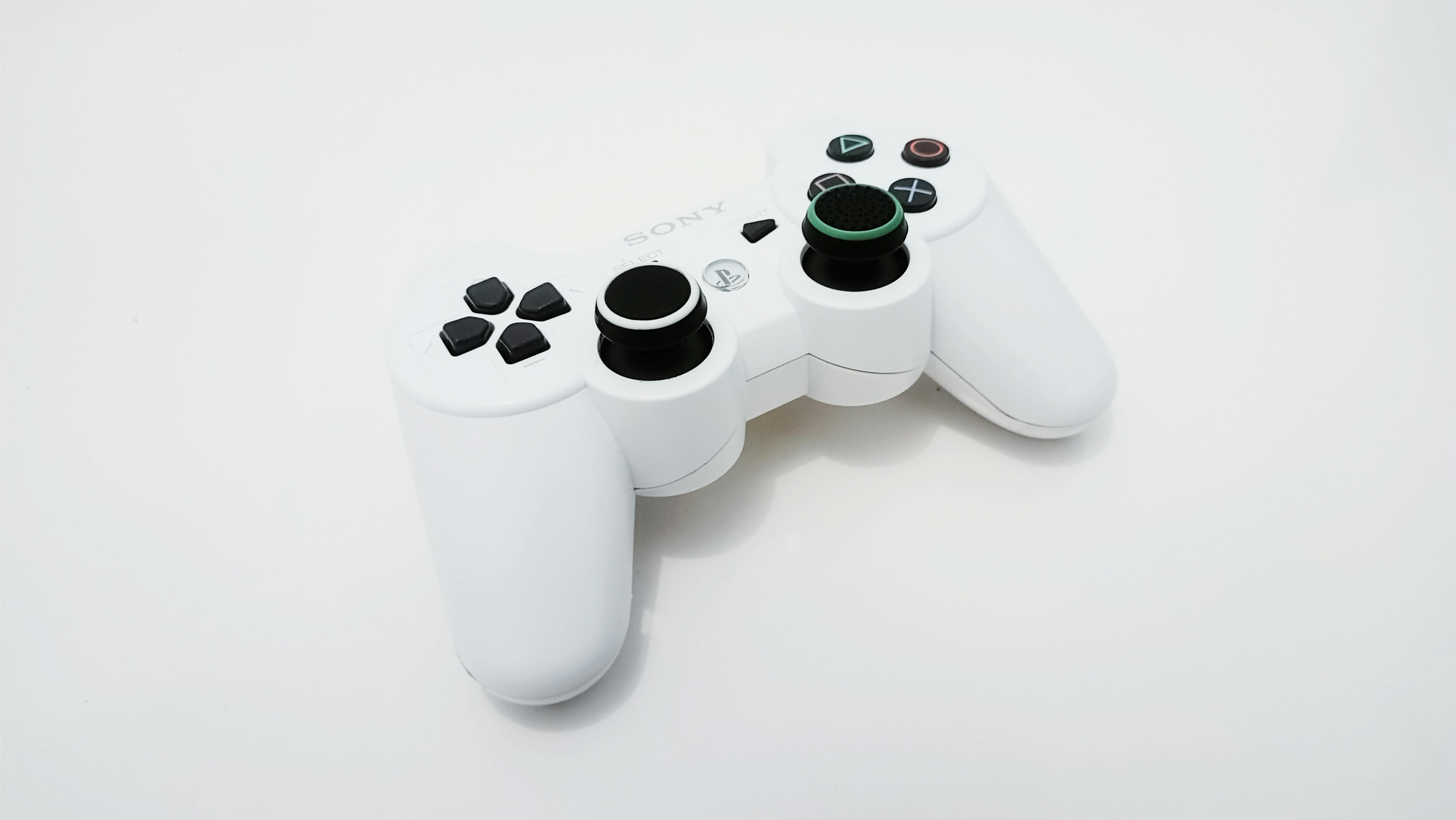 Close-up of a white gaming controller, ideal for PlayStation console enthusiasts.