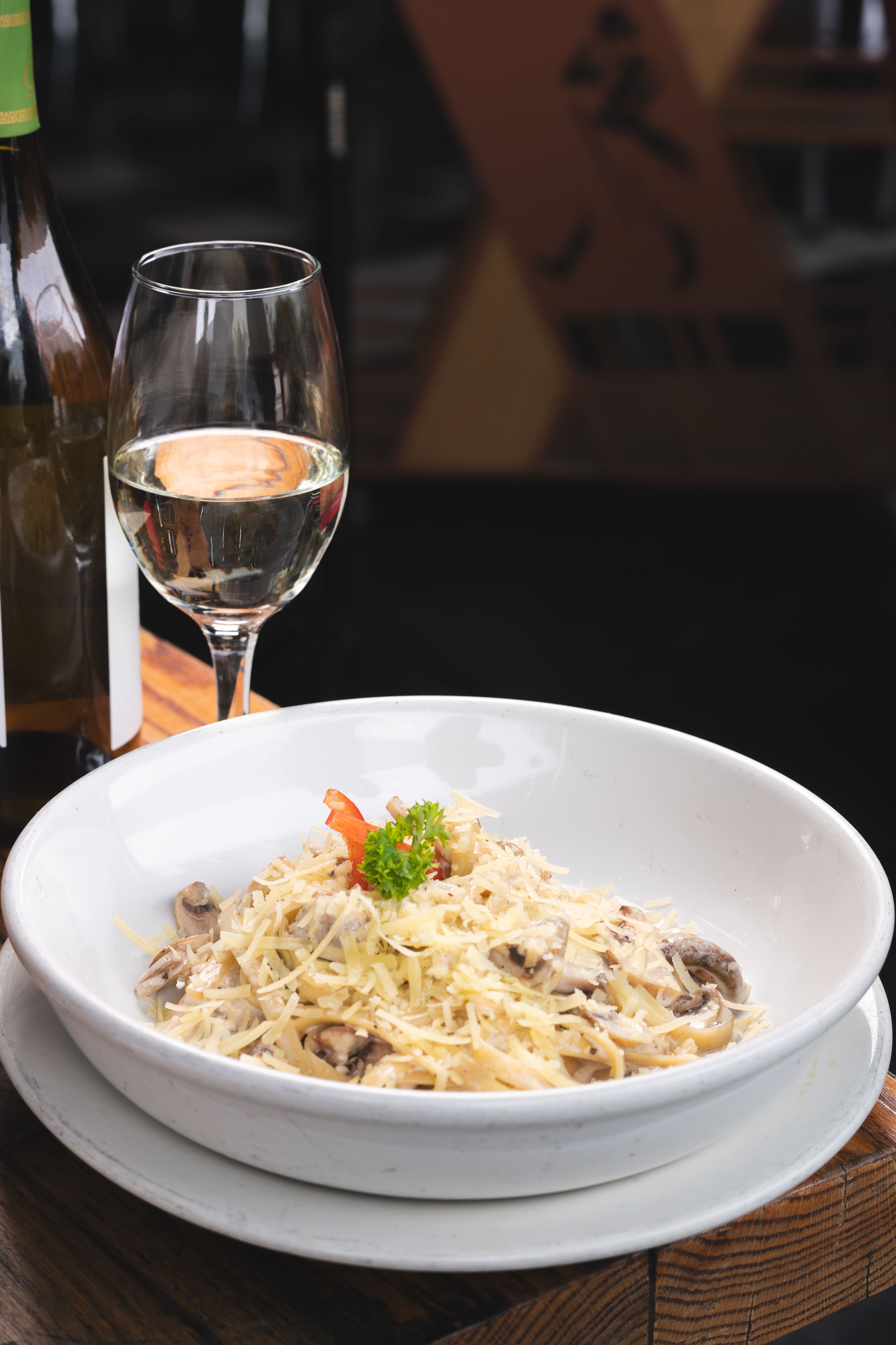 Elegant pasta dish served with white wine, perfect for fine dining.