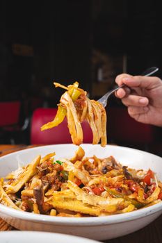 A vibrant plate of Italian pasta with fresh vegetables and mushrooms, perfect for food lovers.