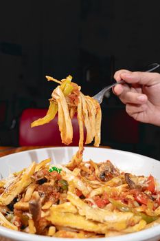 A mouthwatering plate of Italian pasta topped with colorful vegetables, cheese, and herbs.