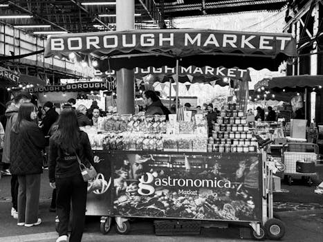 Black and white image of Borough Market's vibrant atmosphere with shoppers and stalls.