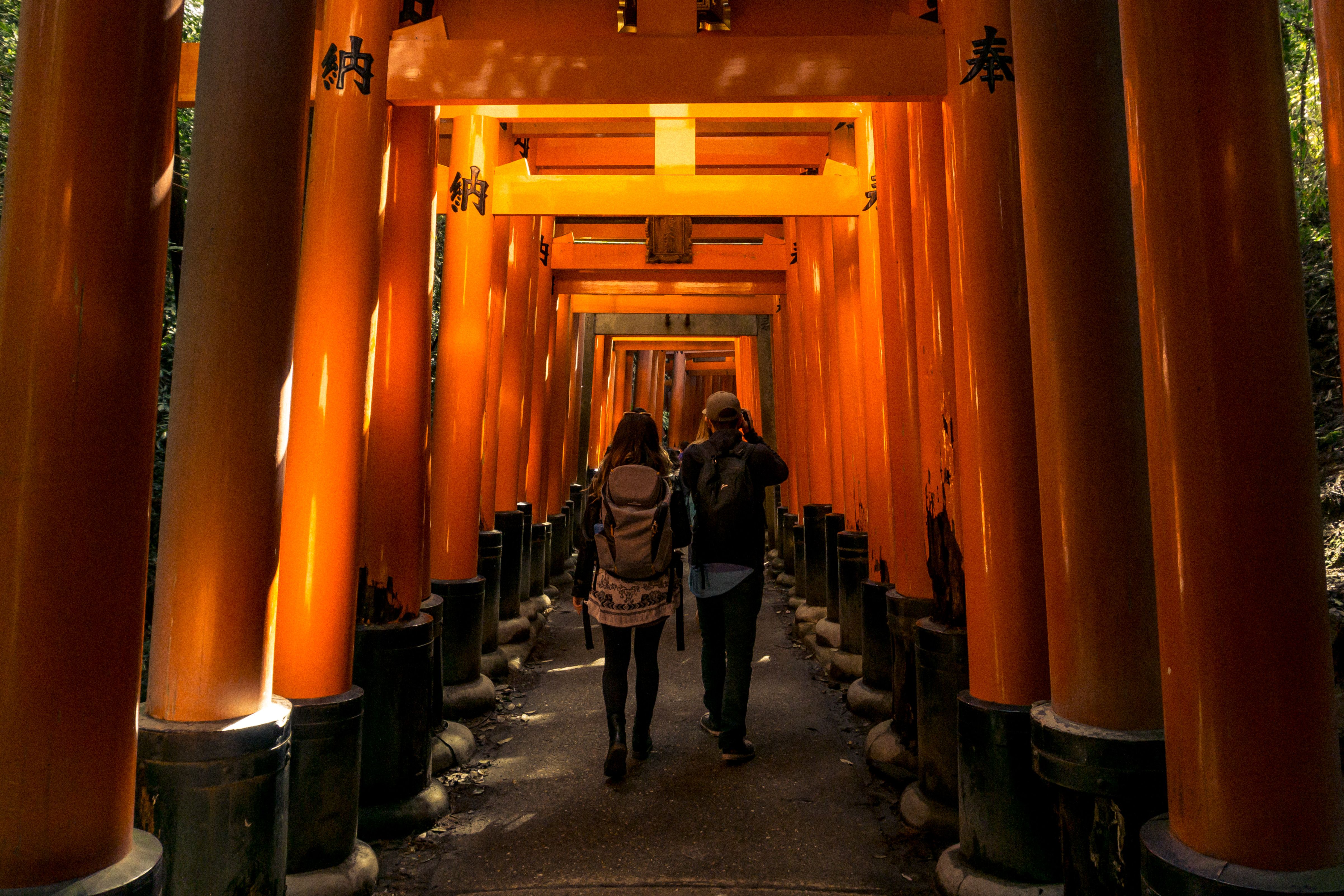 Two People Walking Through Fushimi Inari Shrine · Free Stock Photo