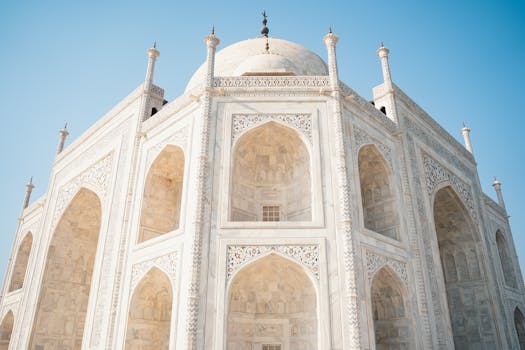Close-up of the stunning architecture of the Taj Mahal on a sunny day in Agra, India.