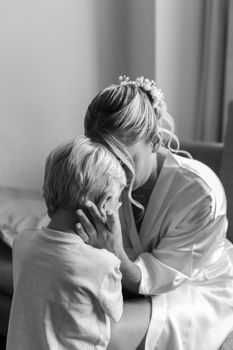 Heartfelt black and white image of mother embracing her child in a tender moment.
