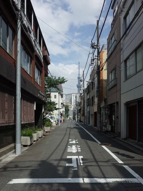 Free Quiet street in Tokyo with a view of the Tokyo Skytree under a blue sky. Stock Photo