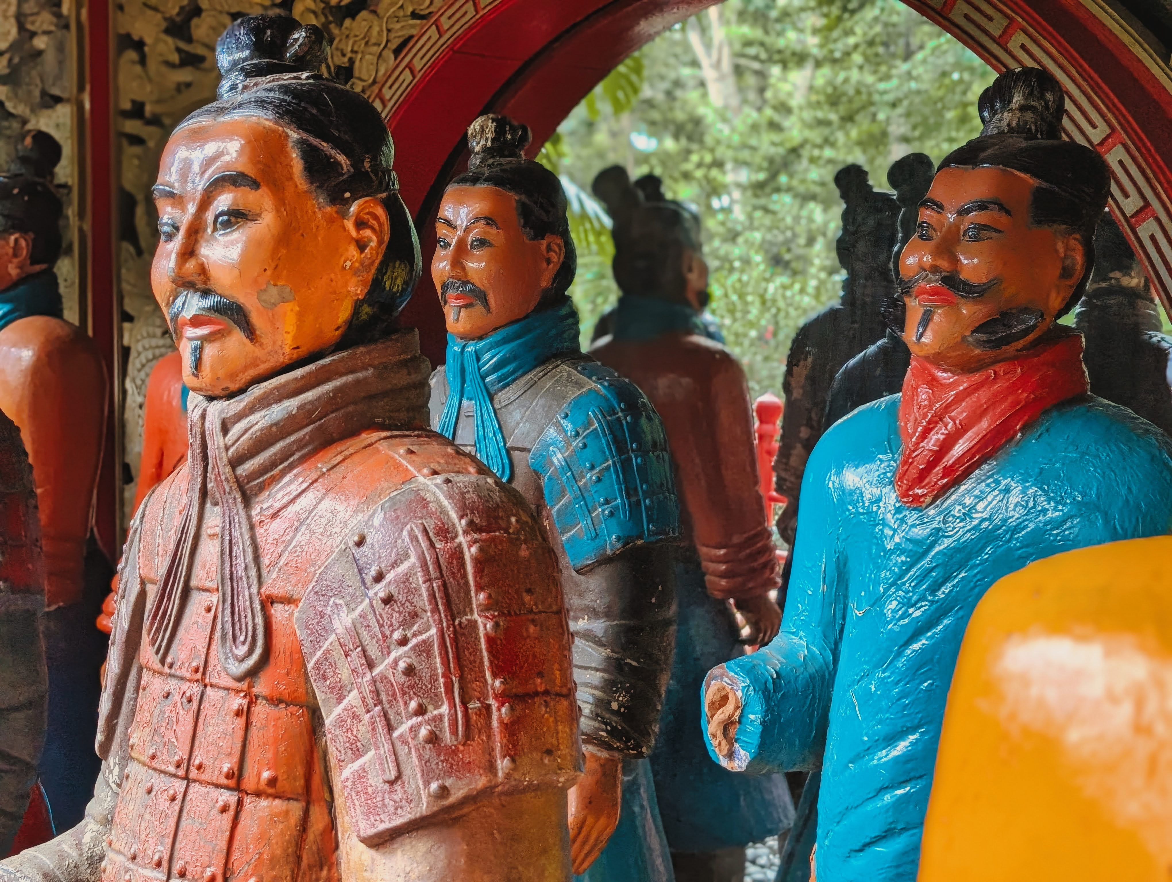 Vibrant terracotta warrior statues with traditional Chinese armor, found outdoors.