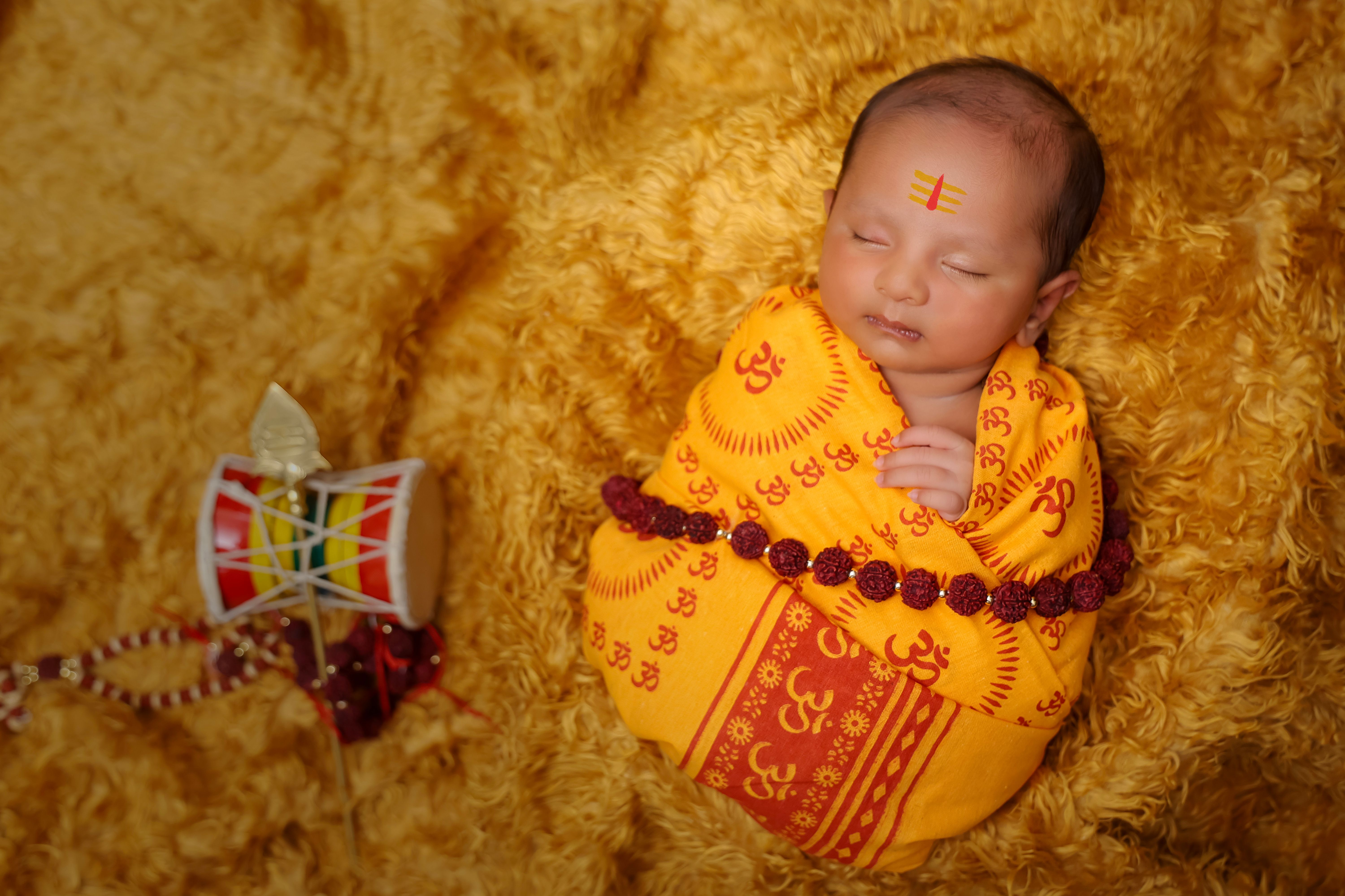 Serene Hindu baby wrapped in traditional attire, symbolizing cultural heritage and purity.