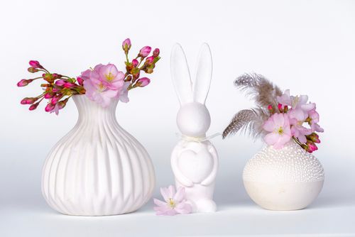 Free Aesthetic still life composition featuring floral arrangements in textured vases with a rabbit figure. Stock Photo