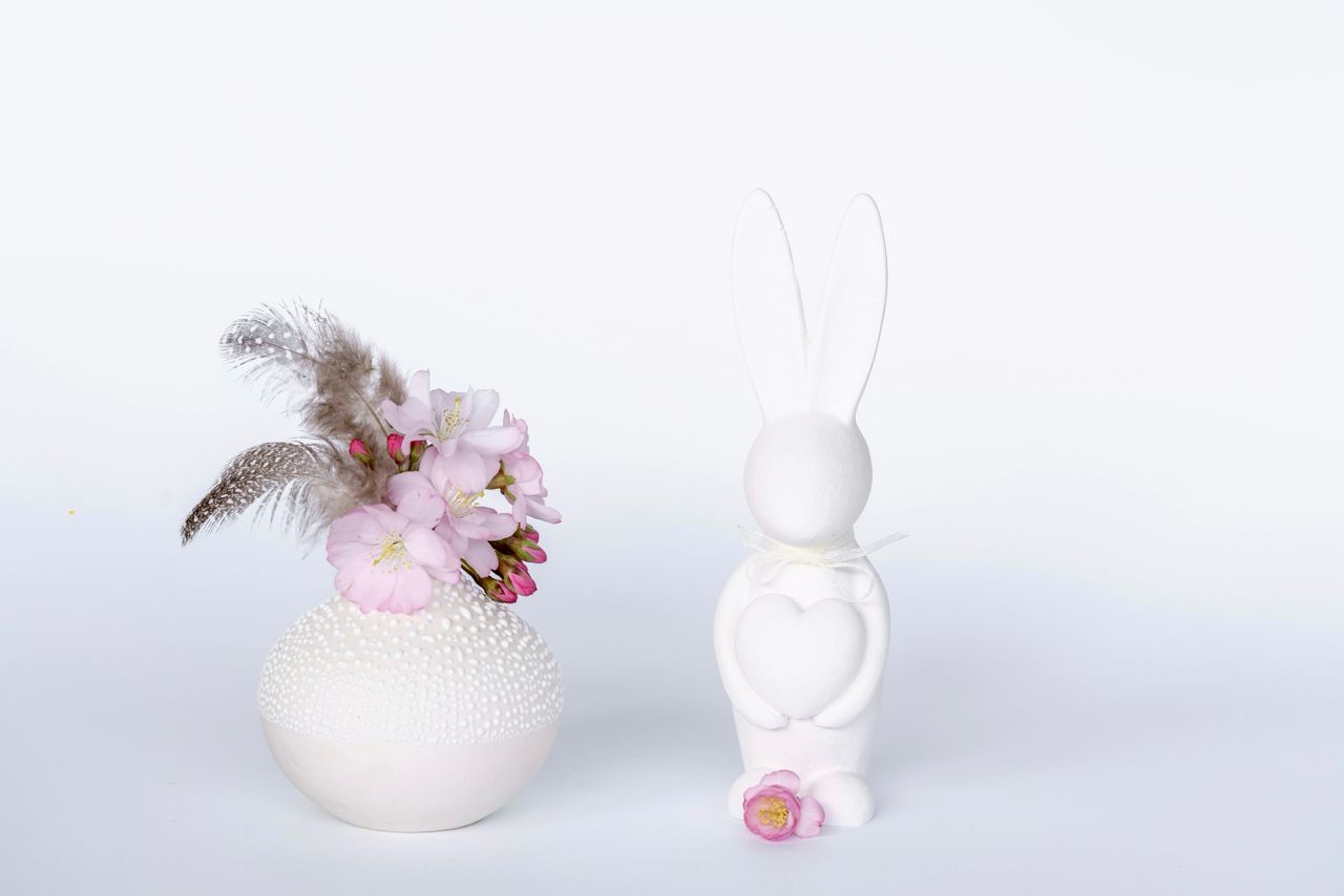 elegant easter themed setup with pink flowers and a white bunny statue