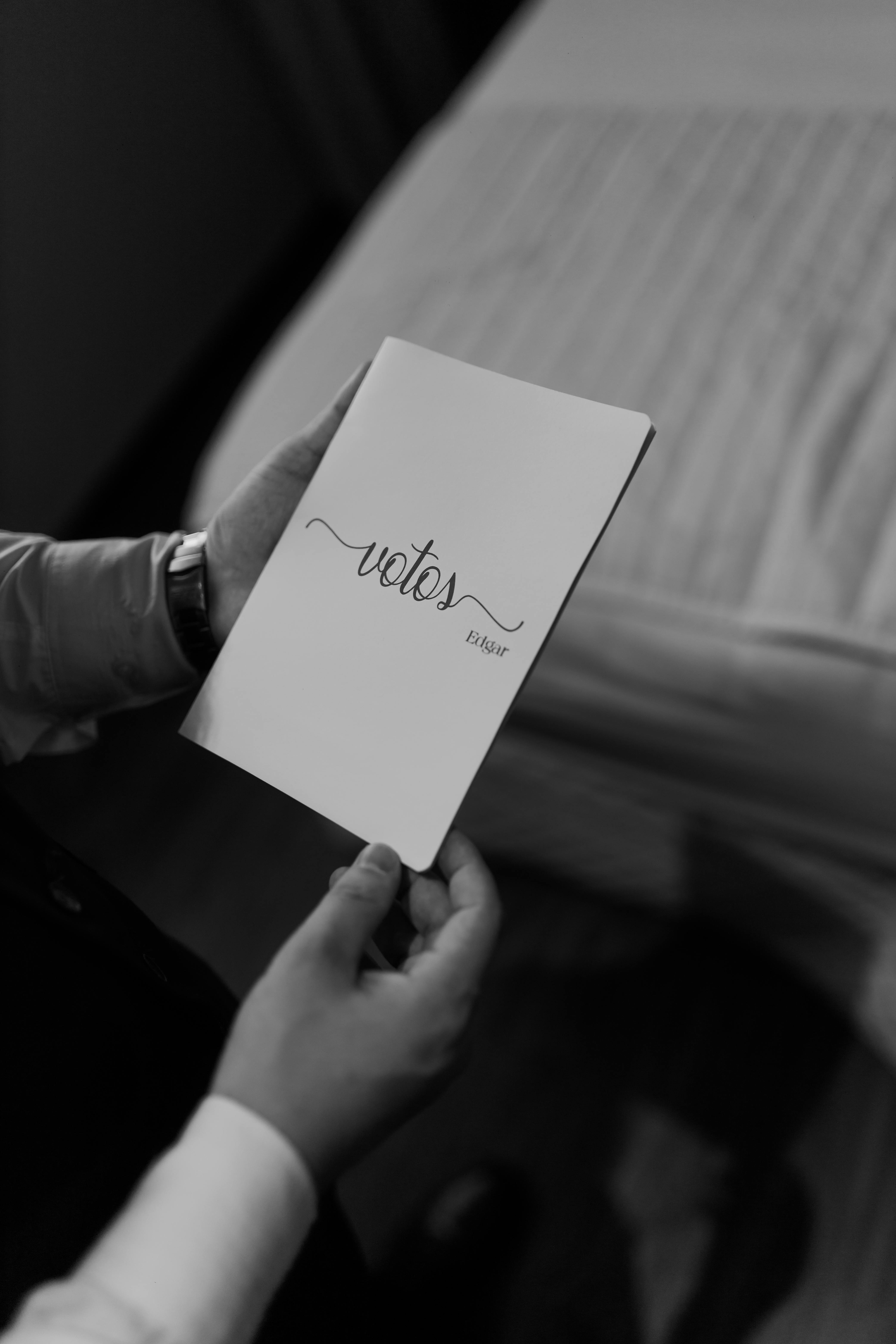 ingyenes Elegáns fekete-fehér fényképen megörökített személy, aki esküvői fogadalomfüzetet tart. Stockfotó