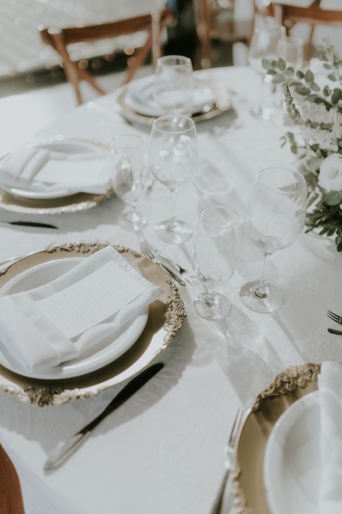 Free Beautifully arranged wedding table setting with floral centerpiece and elegant dinnerware. Stock Photo
