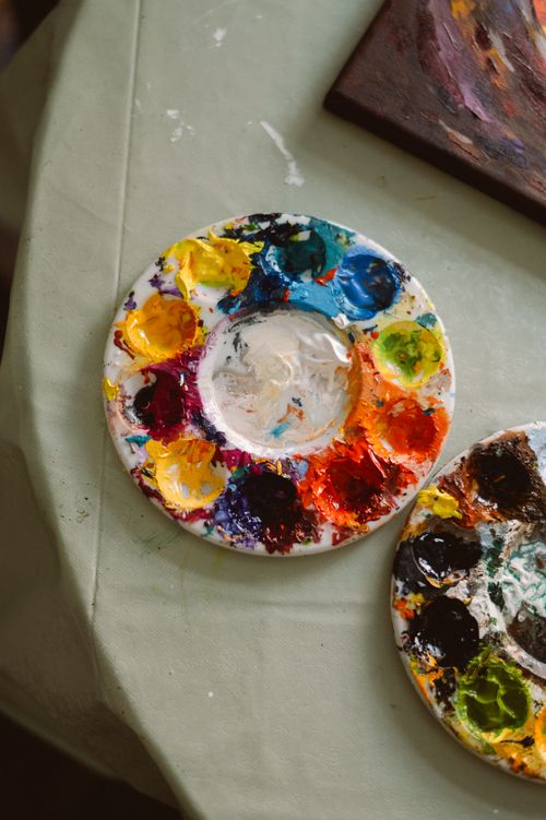 Free Close-up of a colorful artist's palette with vibrant pigments in a creative workspace. Stock Photo