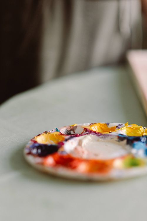 Free Vibrant paint palette in a sunlit studio setting, capturing creative spirit. Stock Photo