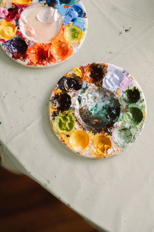 Free Vibrant artist palettes filled with paints on a creative workspace table. Stock Photo
