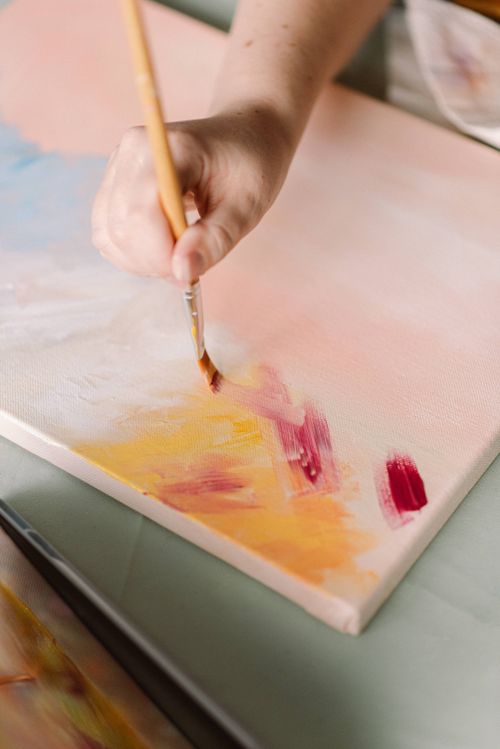 Free Close-up of a hand painting vibrant colors on a canvas, highlighting artistic creativity and process. Stock Photo