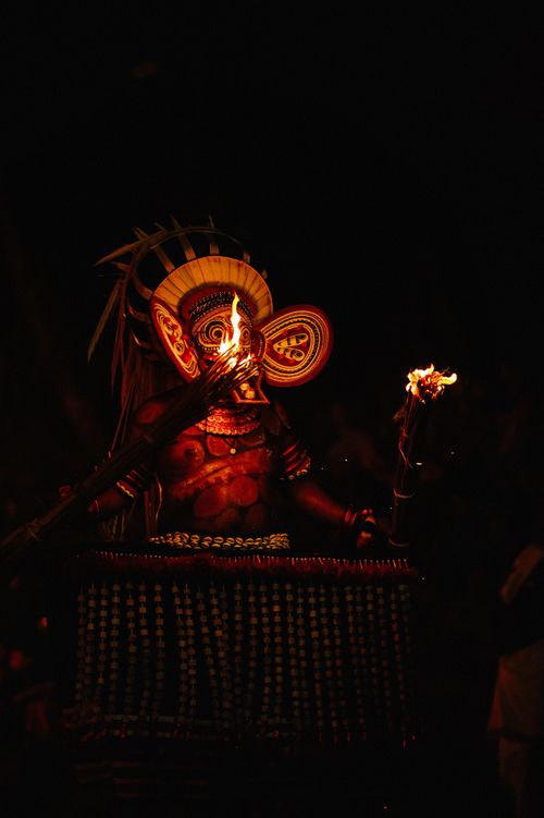 Free A captivating night scene of the traditional Theyyam ritual dance performed with vibrant costumes and firelight. Stock Photo