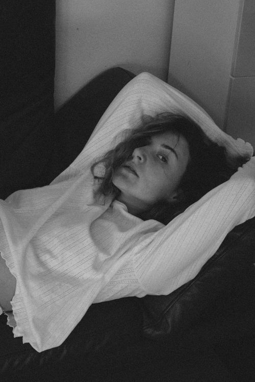 Free Monochrome photo of a woman relaxing on a sofa, exuding a calm and introspective mood. Stock Photo