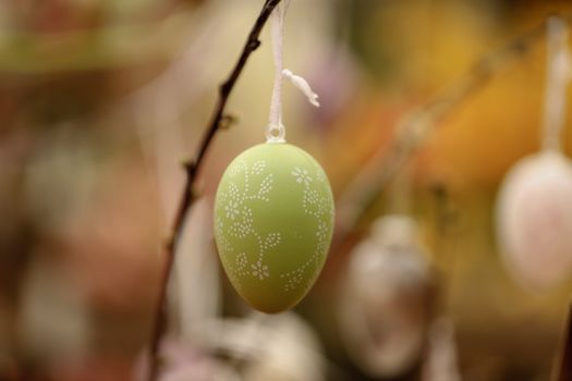 Colorful easter egg hanging on a branch, perfect for spring decoration and celebration.