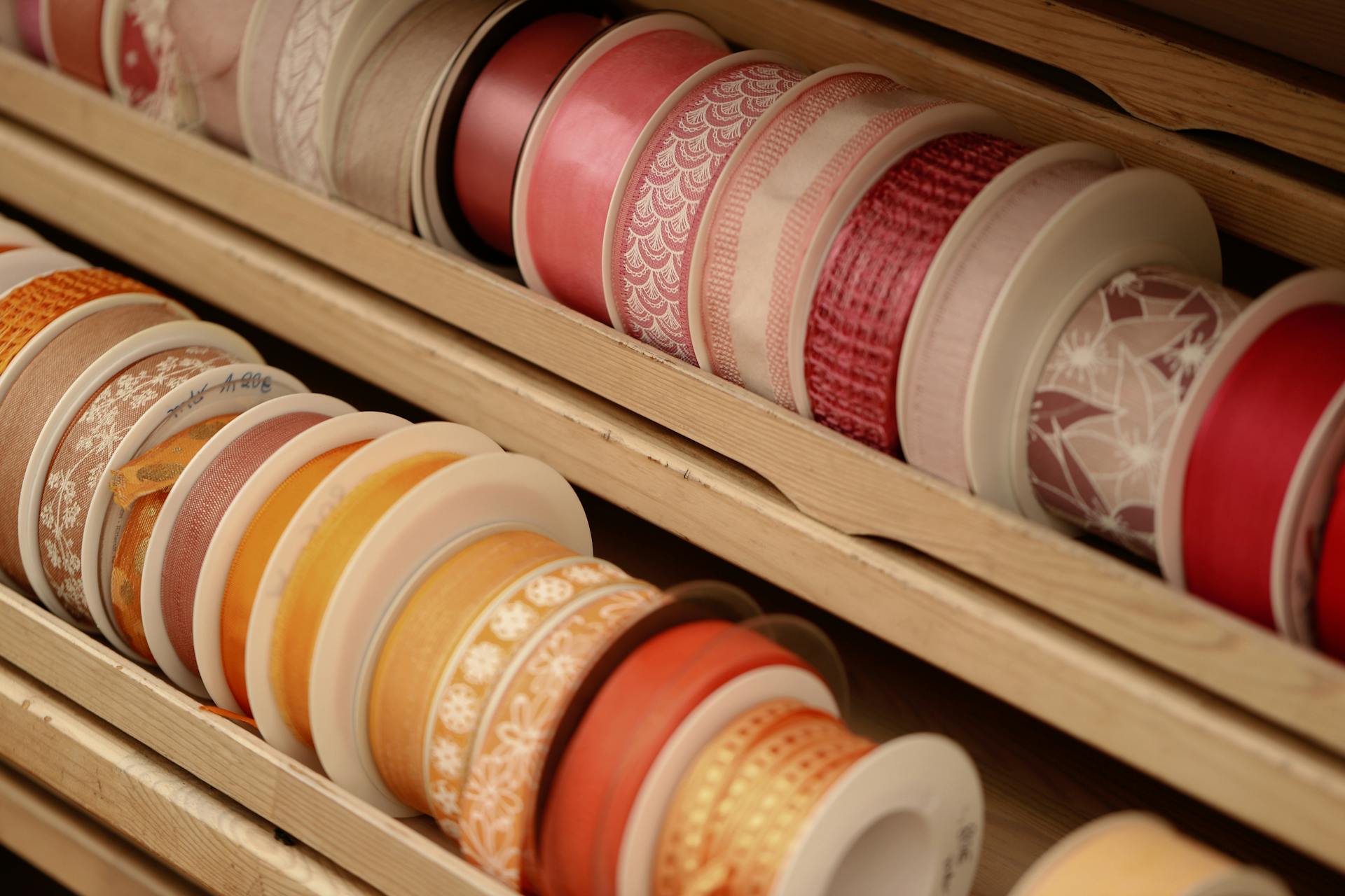 A vibrant collection of decorative ribbons neatly organized in a wooden display.