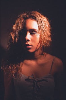 这幅女性肖像运用戏剧性的灯光和卷发，突出了她的面部特征