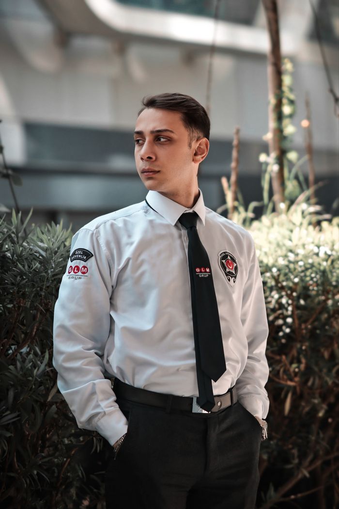 A uniformed security guard standing outside a building