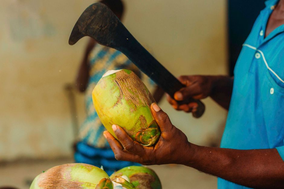A bottle of Bintang beer and a fresh young coconut on a beach in Indonesia