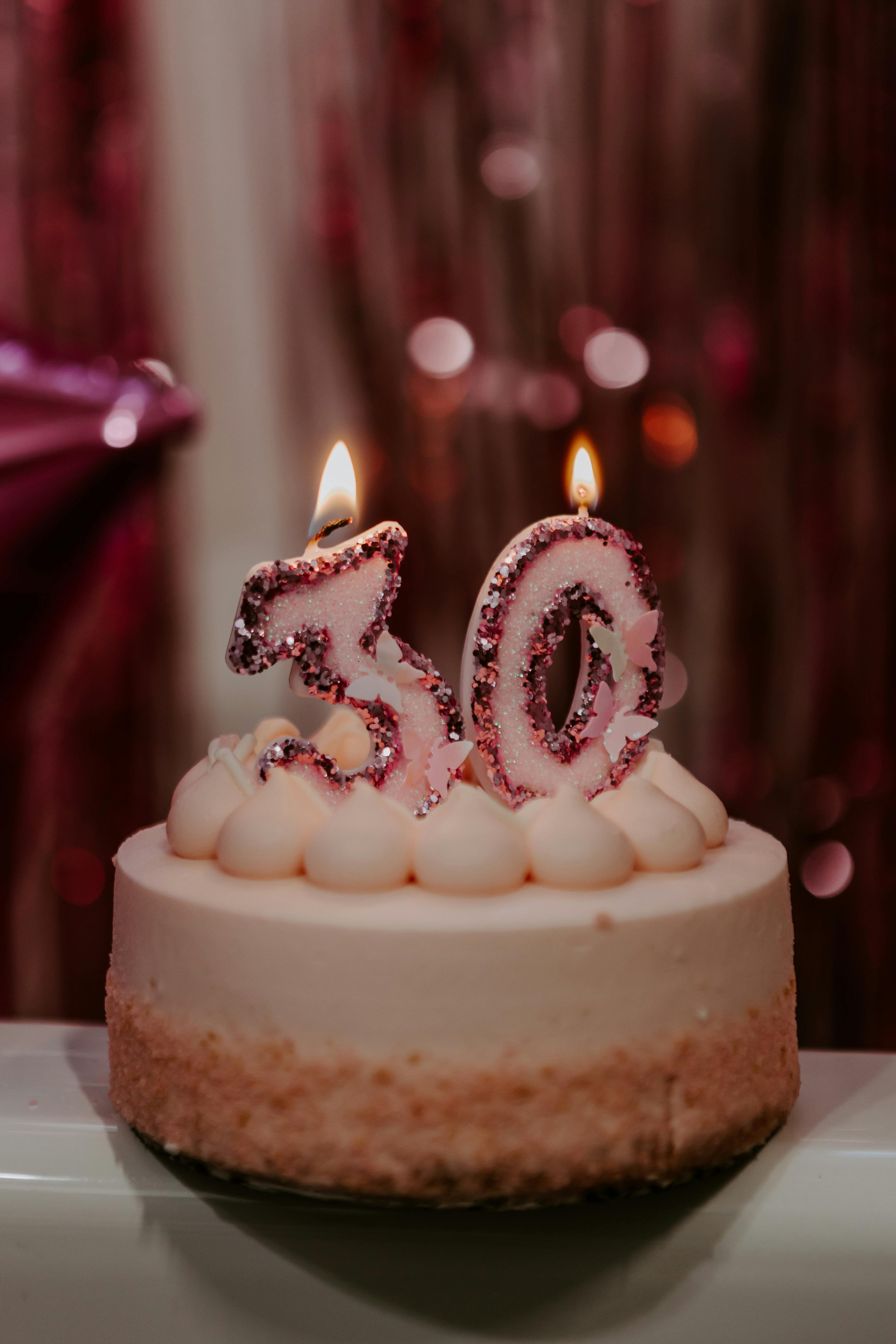 Celebrate the big 3-0 with this elegant birthday cake featuring lit number candles.