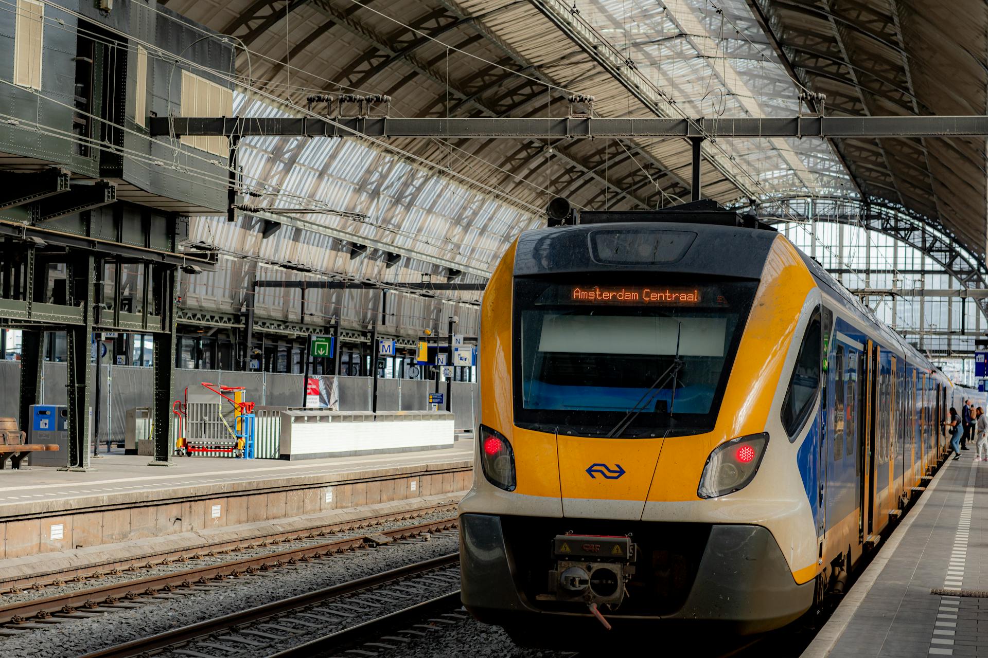 Interior view of a train at Amsterdam Centraal Station during the day.