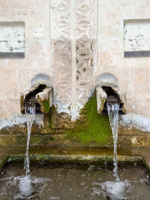 Free A stone double fountain in Palu, Elazığ, Türkiye with intricate carvings and flowing water. Stock Photo