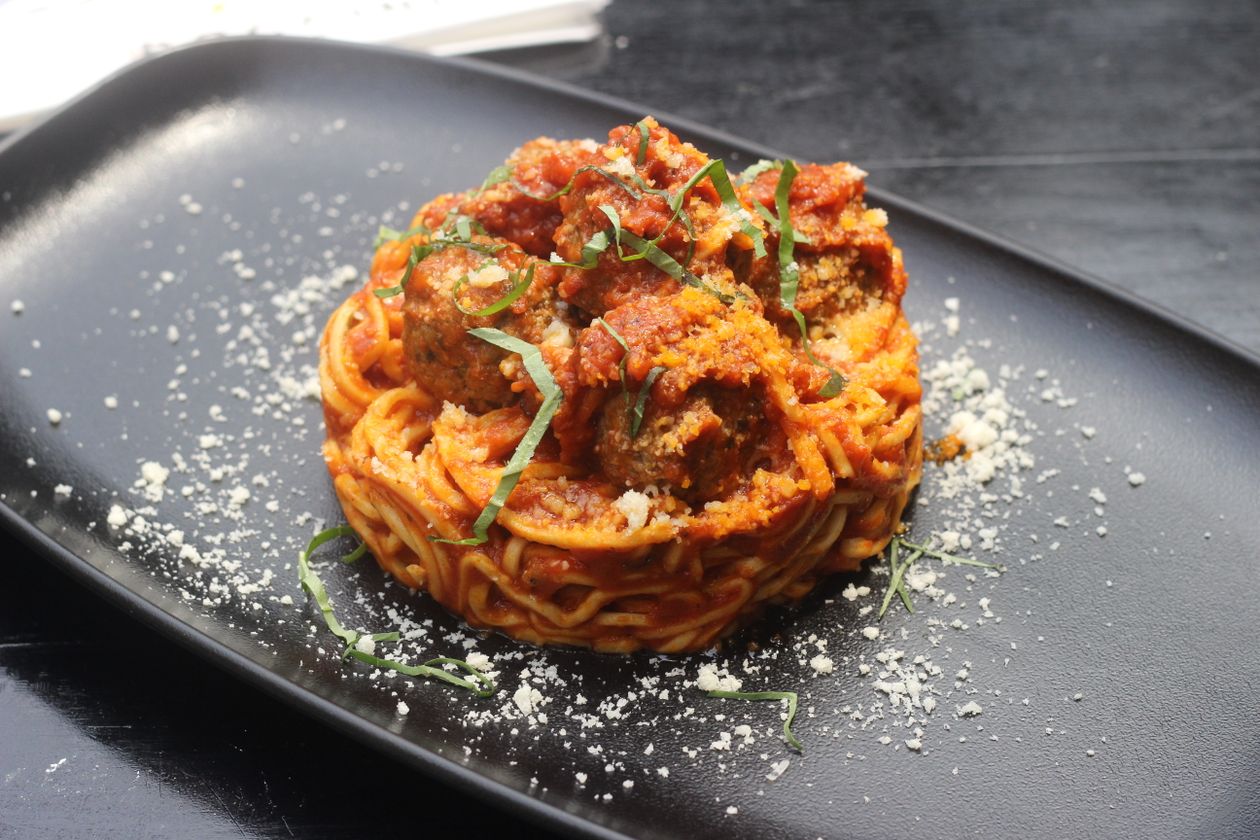 Spaghetti and chicken meatballs plated with fresh basil and marinara sauce