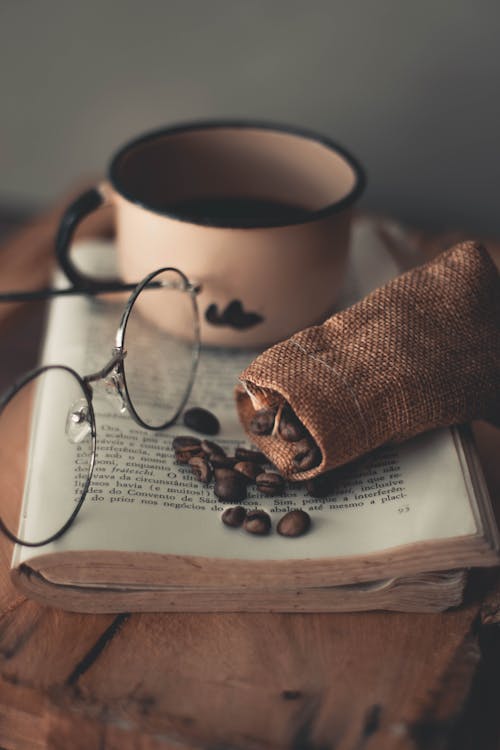 Black Framed Eyeglasses Beside A Cup