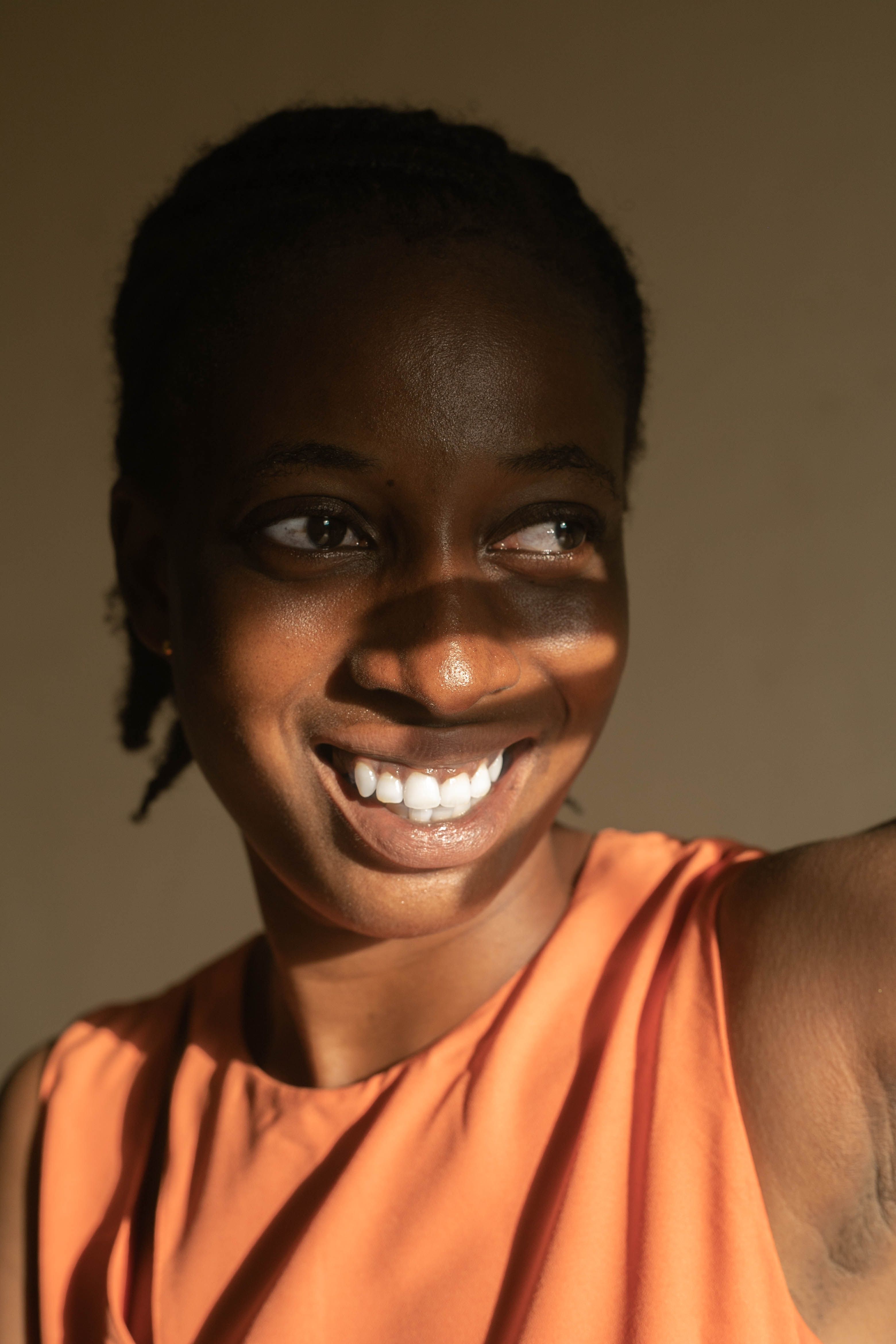 Joyful Black Woman in Vibrant Orange Dress  Free Stock Photo