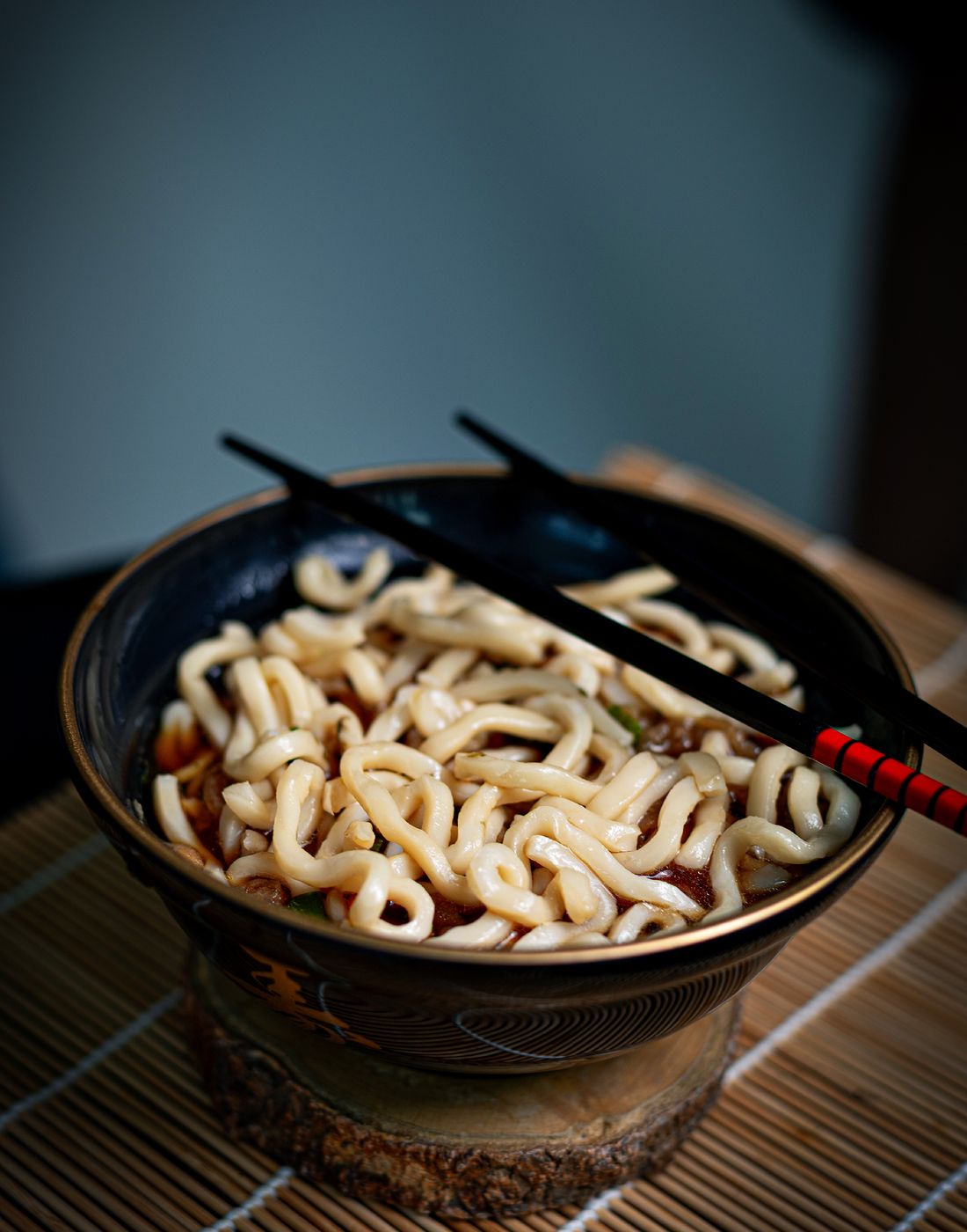 A beautifully presented bowl of udon noodles with chopsticks, perfect for Asian cuisine lovers.