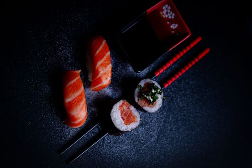 Free A vibrant display of salmon sushi and maki rolls with chopsticks and soy sauce, shot from above. Stock Photo