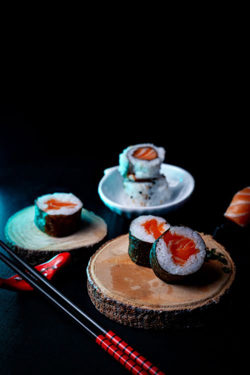 Free A vibrant display of salmon sushi rolls artistically arranged on wooden platters, perfect for food lovers. Stock Photo