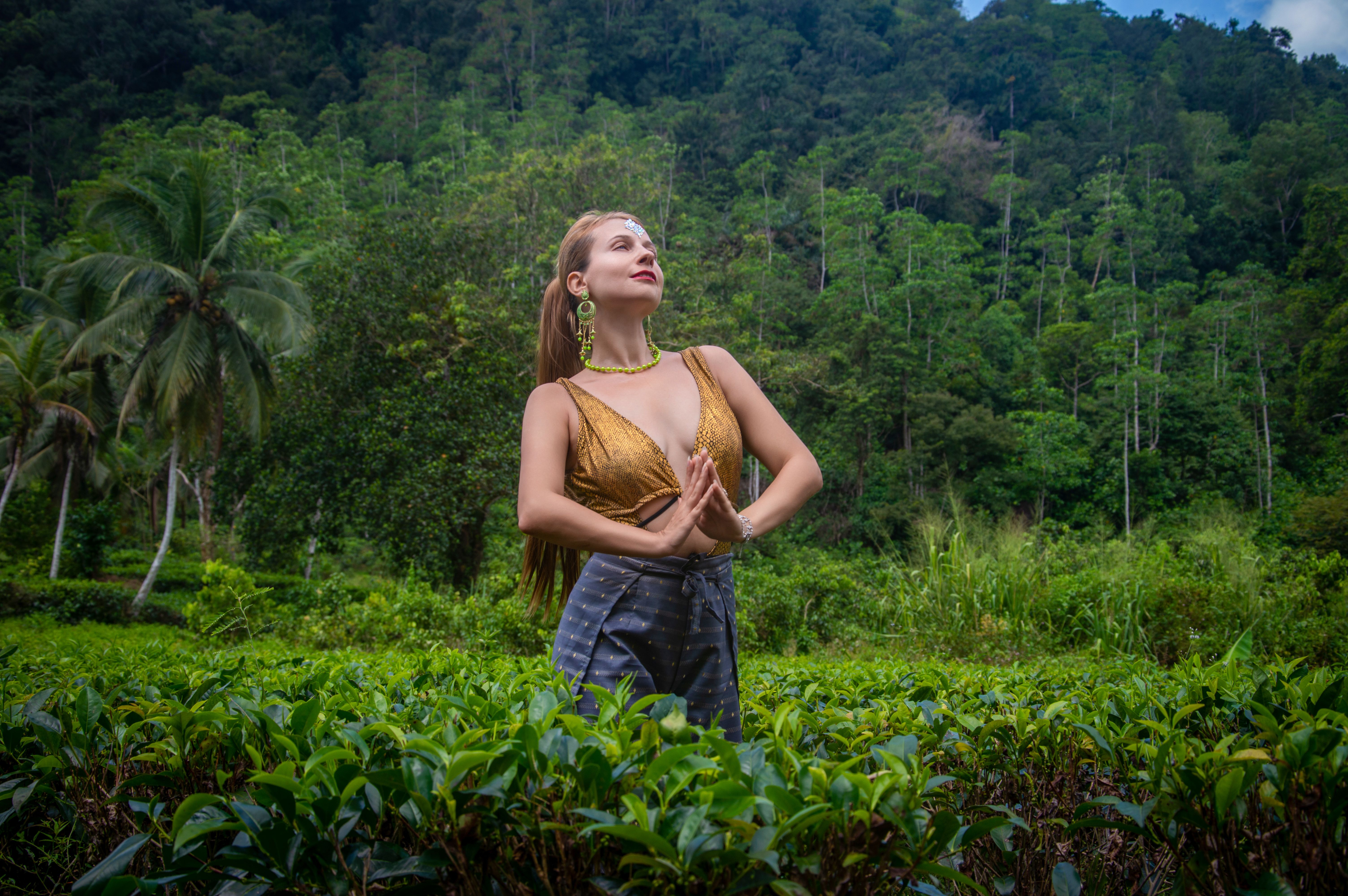 A woman in a serene yoga pose in lush tropical surroundings, symbolizing tranquility and nature.
