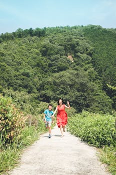 Joyful children running on a forest path. Summer day fun and nature exploration.